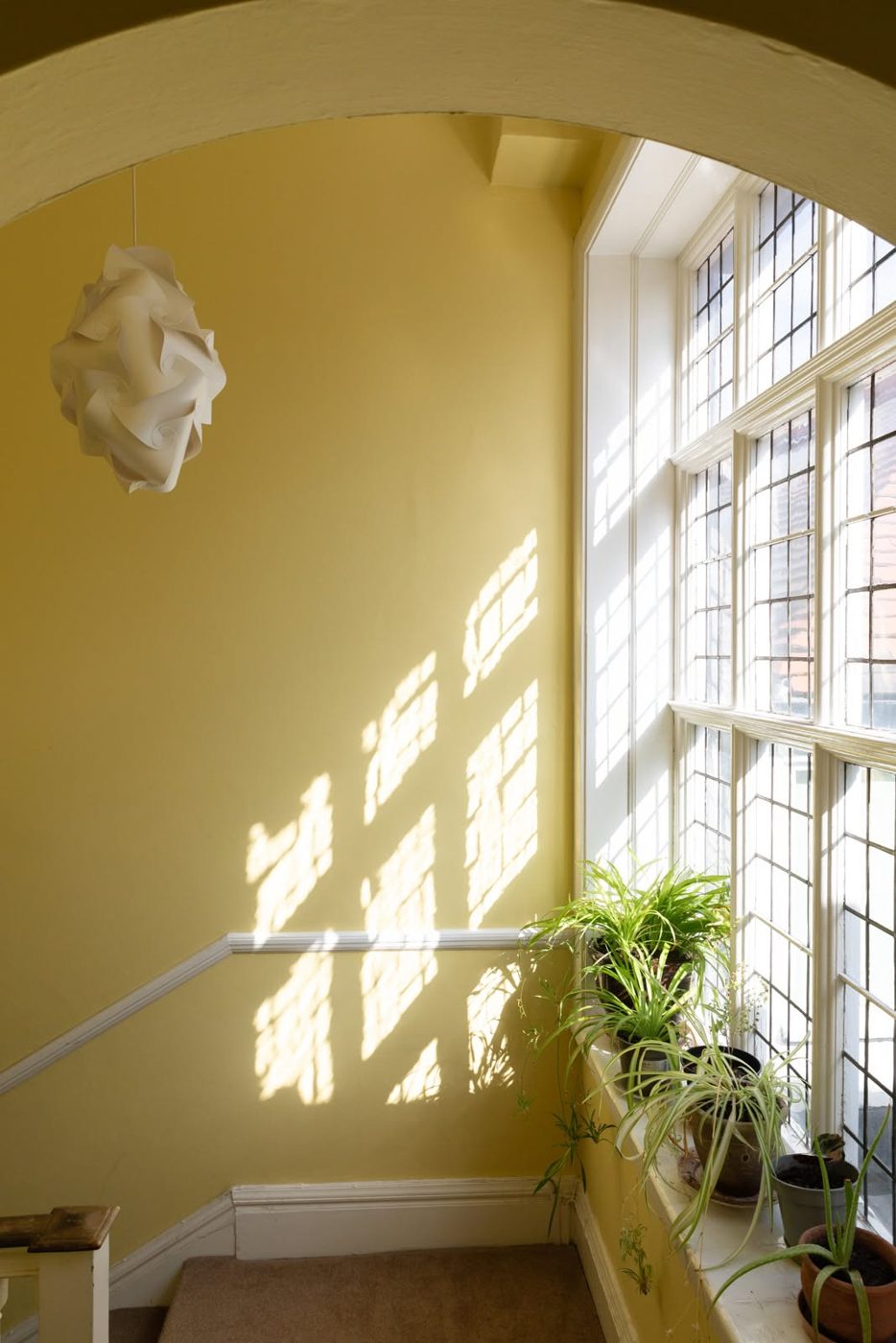 Sunlit alcove in heritage yellow with restored sash window
