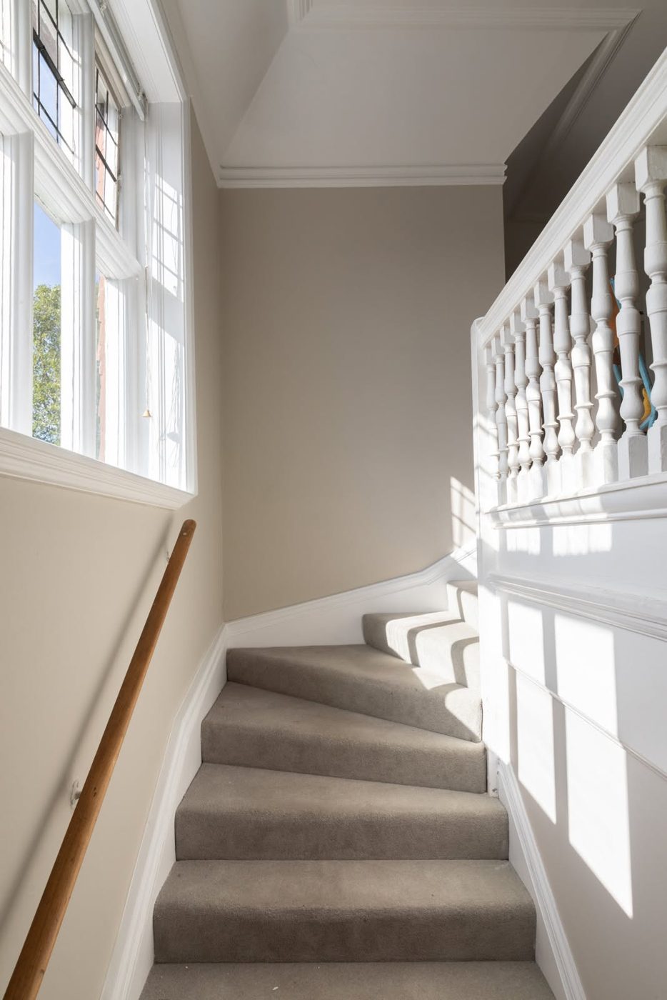 Bright staircase with crisp white balustrade and woodwork